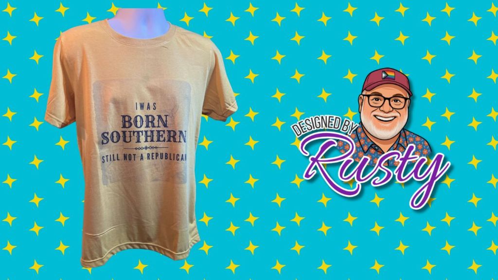Mustard yellow T-shirt reading “I Was Born Southern, Still Not a Republican,” displayed on a mannequin against a turquoise background with yellow stars and the Designed by Rusty logo.